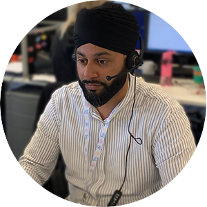 Gurdip Chana from HF Assist sitting at an office desk, using a headset to answer a phone call